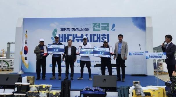 13일 제8회 화성시장배 전국바다낚시대회 수상자들이 트로피와 상금을 받고 기념촬영을 하고 있다.